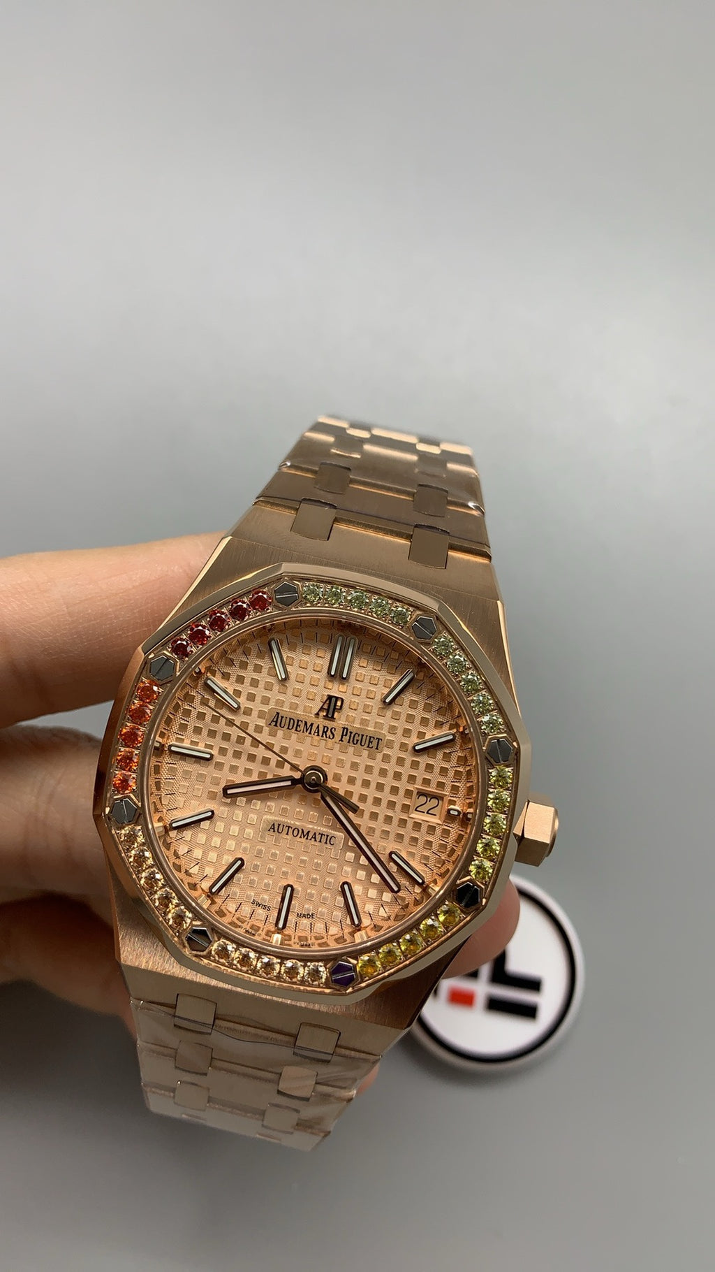 Audemars Piguet Royal Oak 15450 | 37MM | ตัวเรือนสแตนเลสสตีลเคลือบสีโรสโกลด์แบบ PVD | ขอบประดับอัญมณีสี彩รุ้ง (Rainbow Bezel) | หน้าปัดสีขาว | กลไกอัตโนมัติ Cal.3120