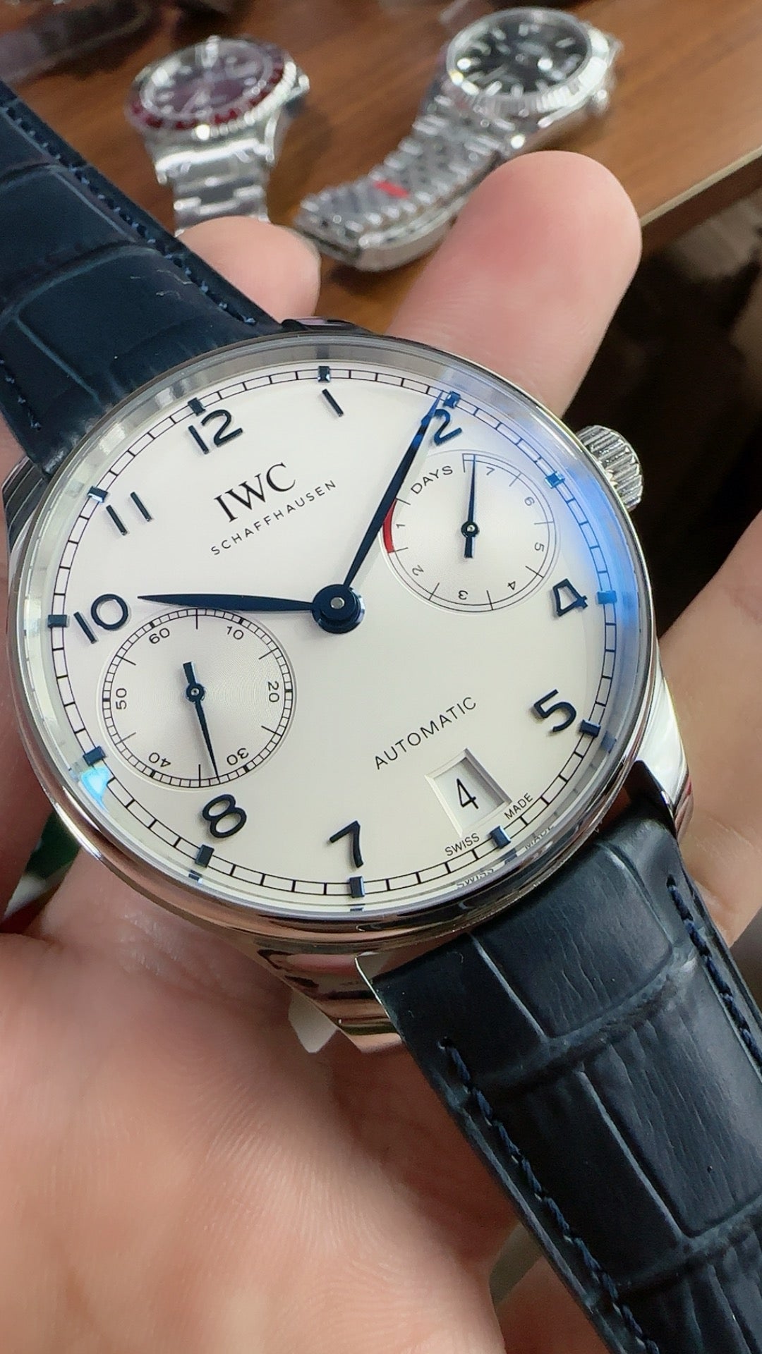IWC Portugieser Automatic IW500705 | 42.3MM | ตัวเรือนสเตนเลสสตีล | หน้าปัดสีขาว | เข็มสีน้ำเงิน | สายหนังจระเข้สีน้ำเงิน | กลไกอัตโนมัติ Cal.52010