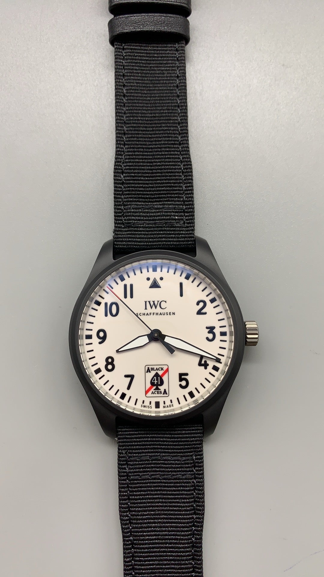 IWC Pilot's Watch Automatic Black Aces | 41MM | ตัวเรือนเซรามิกสีดำ | หน้าปัดสีขาวพิมพ์โลโก้ Black Aces | สายผ้า NATO สีดำ | กลไกอัตโนมัติ Cal.32100