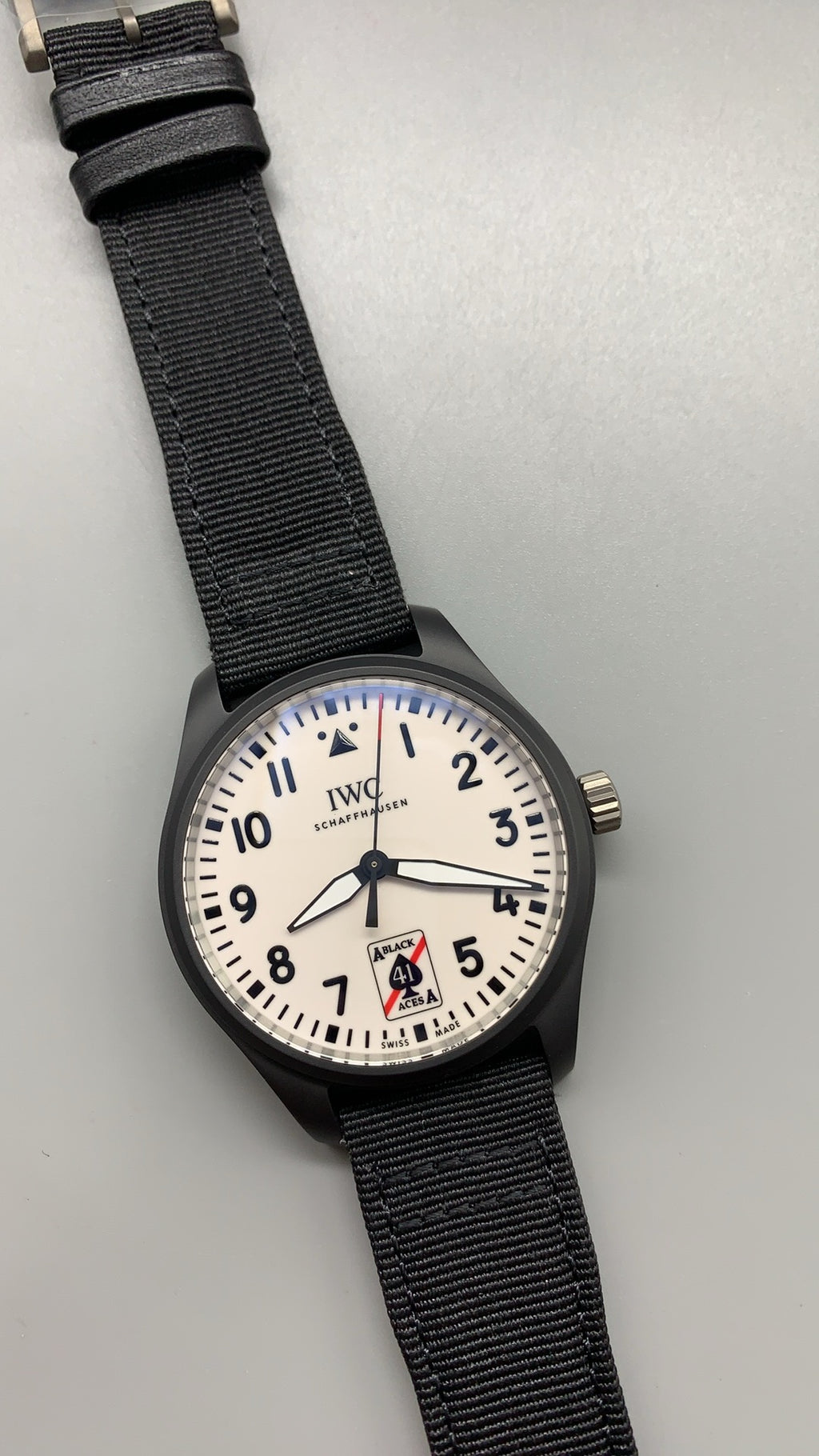 IWC Pilot's Watch Automatic Black Aces | 41MM | ตัวเรือนเซรามิกสีดำ | หน้าปัดสีขาวพิมพ์โลโก้ Black Aces | สายผ้า NATO สีดำ | กลไกอัตโนมัติ Cal.32100